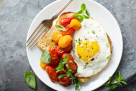 Multigrain toast with fried egg, fresh herbs and roasted tomatoes