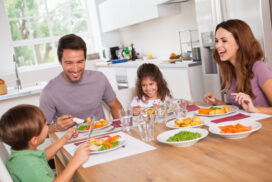 Family laughing around a good meal in kitchen